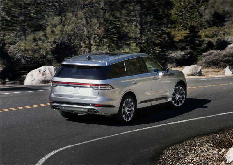 A 2023 Lincoln Aviator® Grand Touring model is shown being driven on a tight turn of a mountain road | Bill Collins Lincoln of Louisville in Louisville KY