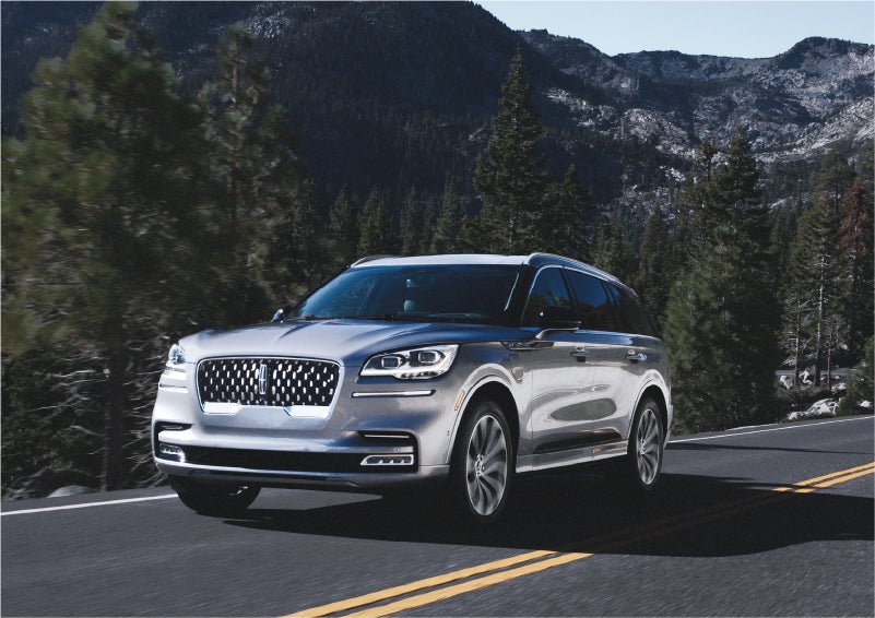 A 2023 Lincoln Aviator® Grand Touring SUV being driven on a winding road to demonstrate the capabilities of all-wheel drive | Bill Collins Lincoln of Louisville in Louisville KY