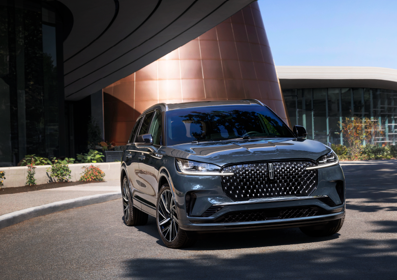 A gray 2025 Lincoln Aviator® SUV is parked outside a modern building with the sun shining. | Bill Collins Lincoln of Louisville in Louisville KY