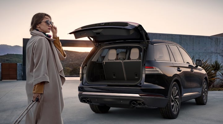 A woman approaches a 2026 Lincoln Aviator® SUV with its rear liftgate open. | Bill Collins Lincoln of Louisville in Louisville KY