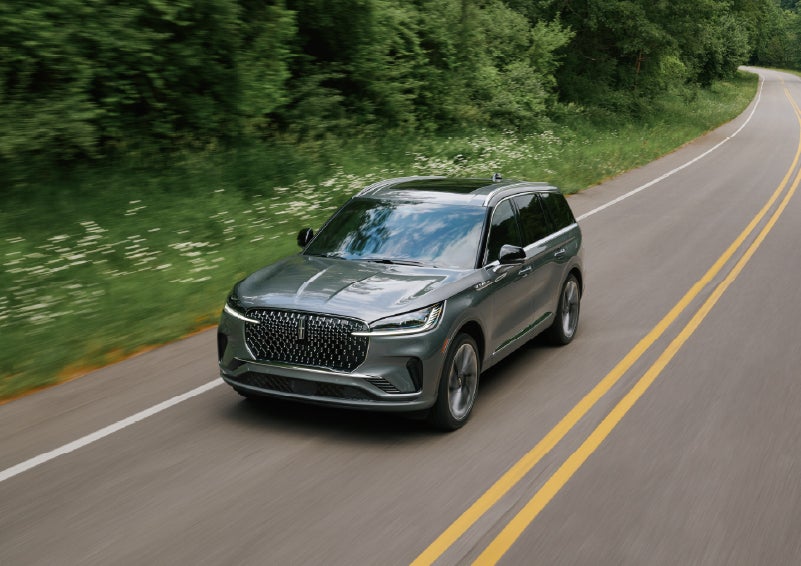 A 2027 Lincoln Aviator® SUV is being driven down a road. | Bill Collins Lincoln of Louisville in Louisville KY