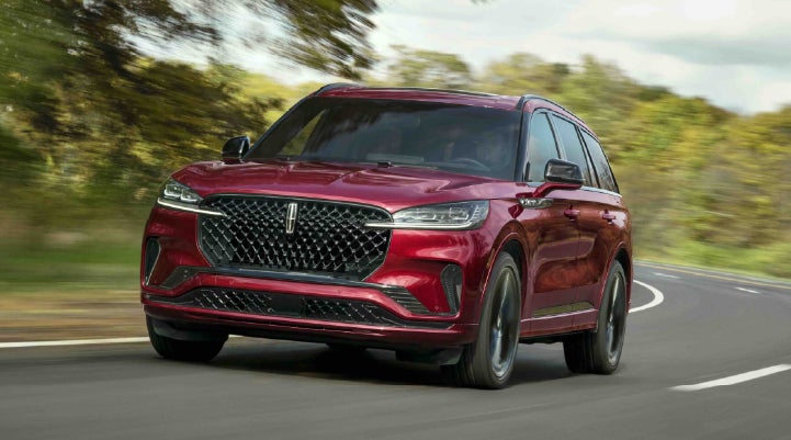 A 2027 Lincoln Aviator® SUV is being driven on a country road | Bill Collins Lincoln of Louisville in Louisville KY